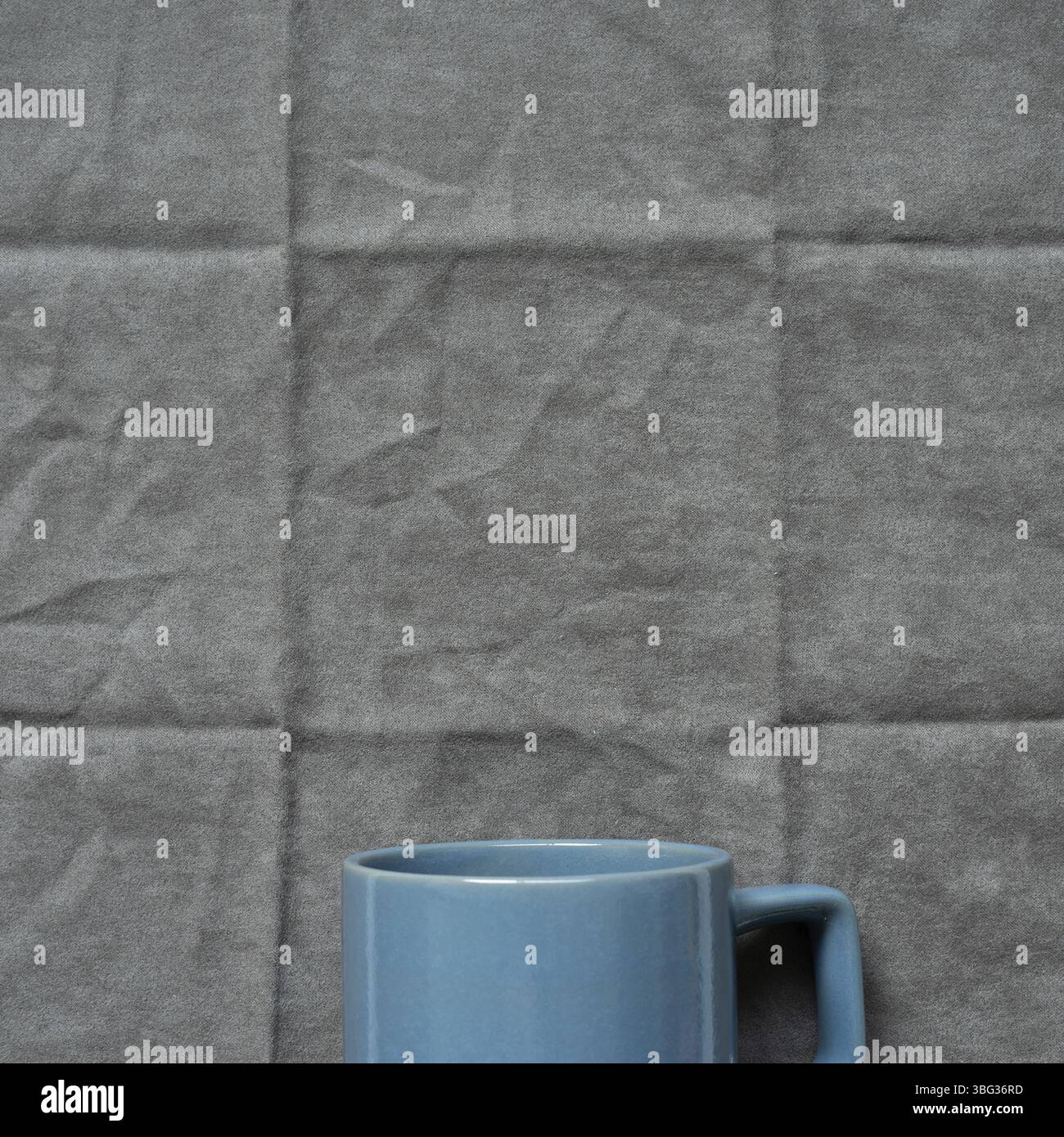 Tasse bleue sur fond de tissu gris. vue de dessus Banque D'Images