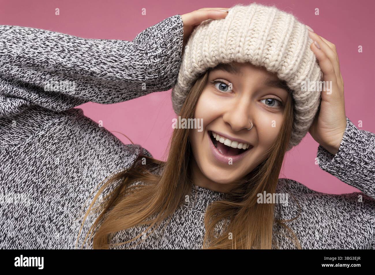 Gros plan photo portrait de beau joli joli positif heureux incroyable drôle joyeux jeune femme blonde portant décontracté chandail gris et chapeau beige Banque D'Images
