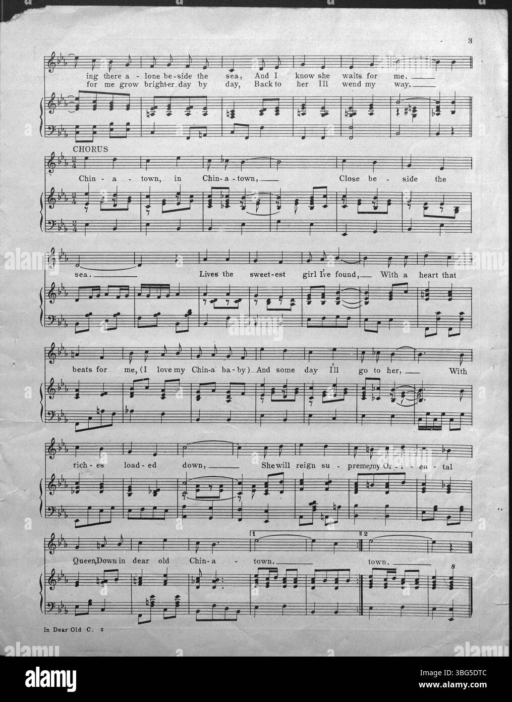 La couverture de 1918 de « In Dear Old China Town » montre des voiliers chinois traditionnels dans le port, avec des bâtiments historiques en arrière-plan, offrant un aperçu de la vie dans Chinatown du début du XXe siècle. Banque D'Images