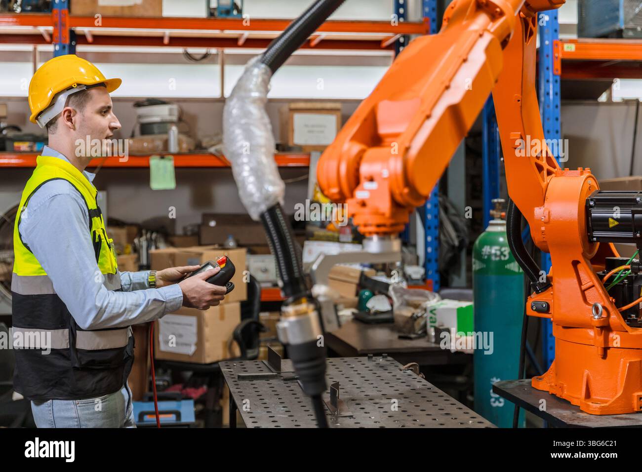 ingénieur professionnel, technicien robotique travaillent dans l'opérateur de contrôle de machine de bras de soudage de robot industriel moderne d'usine Banque D'Images
