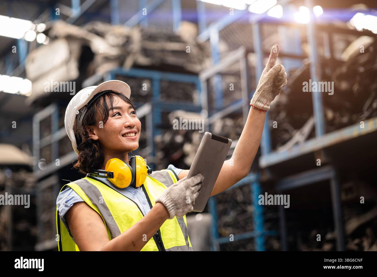 Heureuse femme noire asiatique technicien ingénieur technicien de matériel travailleur d'entrepôt de stock de matériel aiment travailler dans l'industrie lourde. Banque D'Images