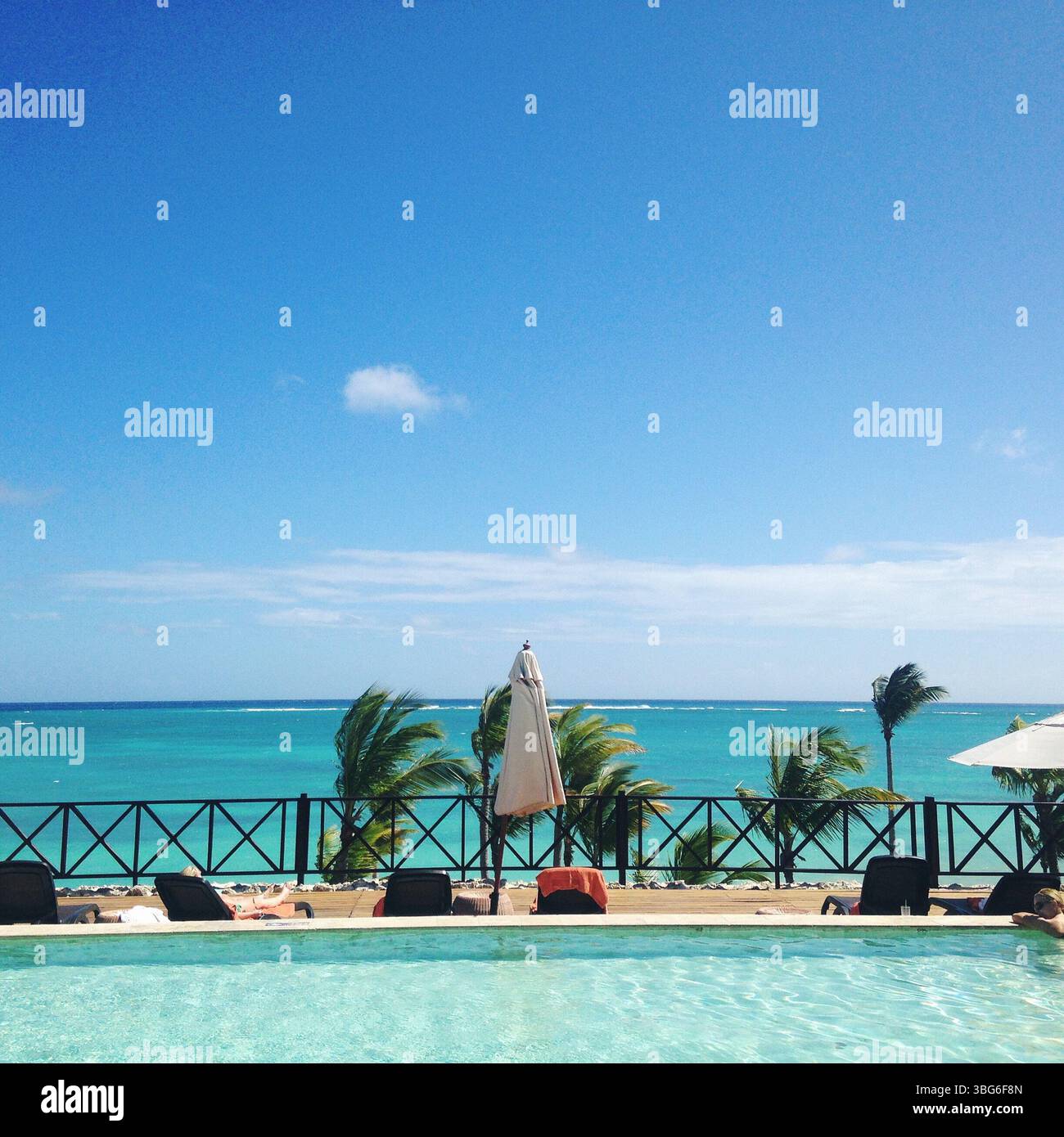 Piscine du complexe en bord de mer avec parasols et palmiers au bord de la mer Banque D'Images