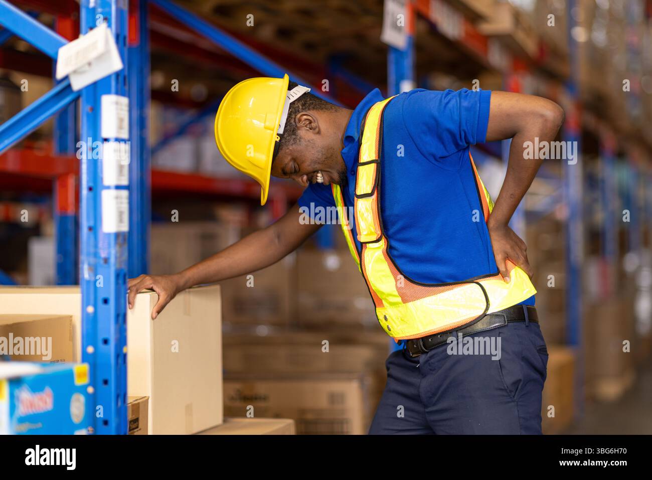 douleur dorsale de travailleur, travailleur salarié africain travaillant dans le stockage d'entrepôt souffrant de problèmes musculaires de santé Banque D'Images