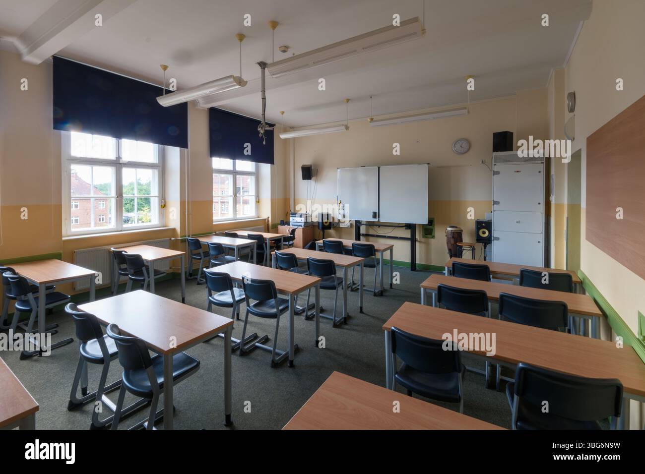 Une salle de classe pleine de tables et de chaises Banque D'Images