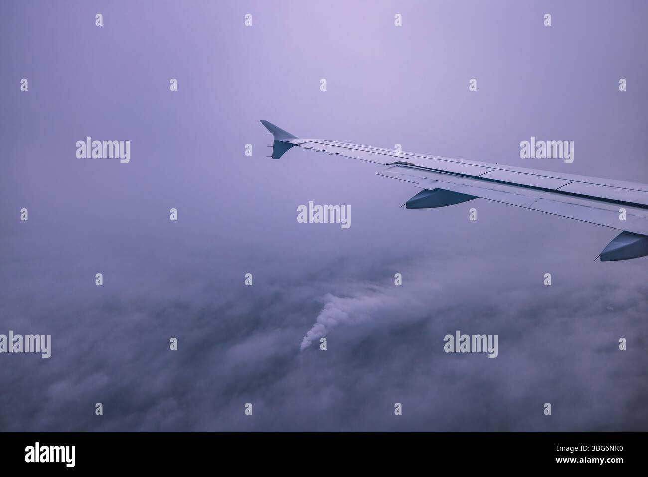 Avion volant au-dessus de nuages brumeux orageux, vue de la fenêtre de l'avion des turbines d'aile et de l'horizon Banque D'Images