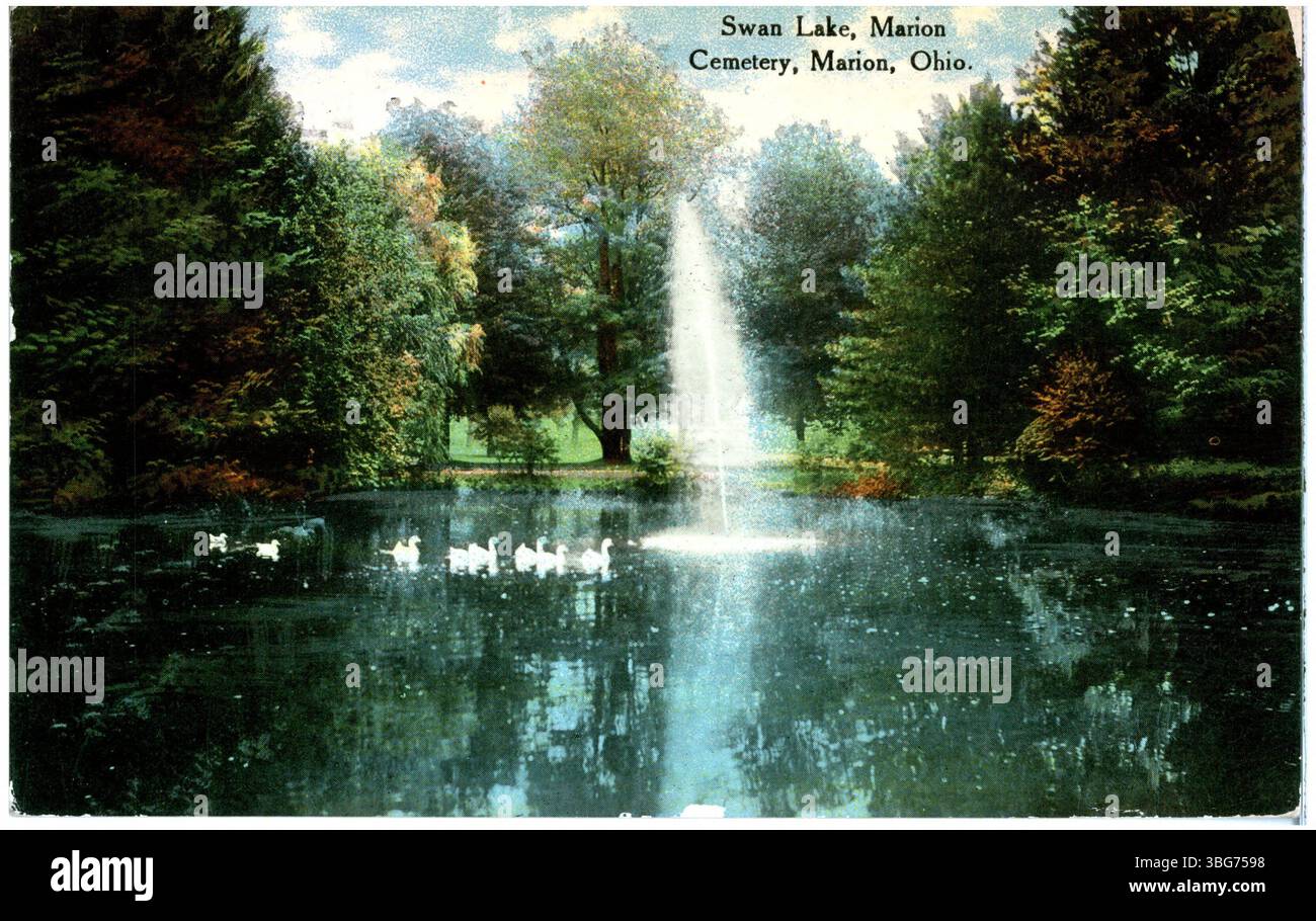 Une photographie en couleur de 1911 représentant le lac des cygnes au cimetière de Marion dans l'Ohio, montrant un étang tranquille entouré d'arbres avec des oiseaux sur l'eau, améliorant l'atmosphère sereine du cimetière. Banque D'Images