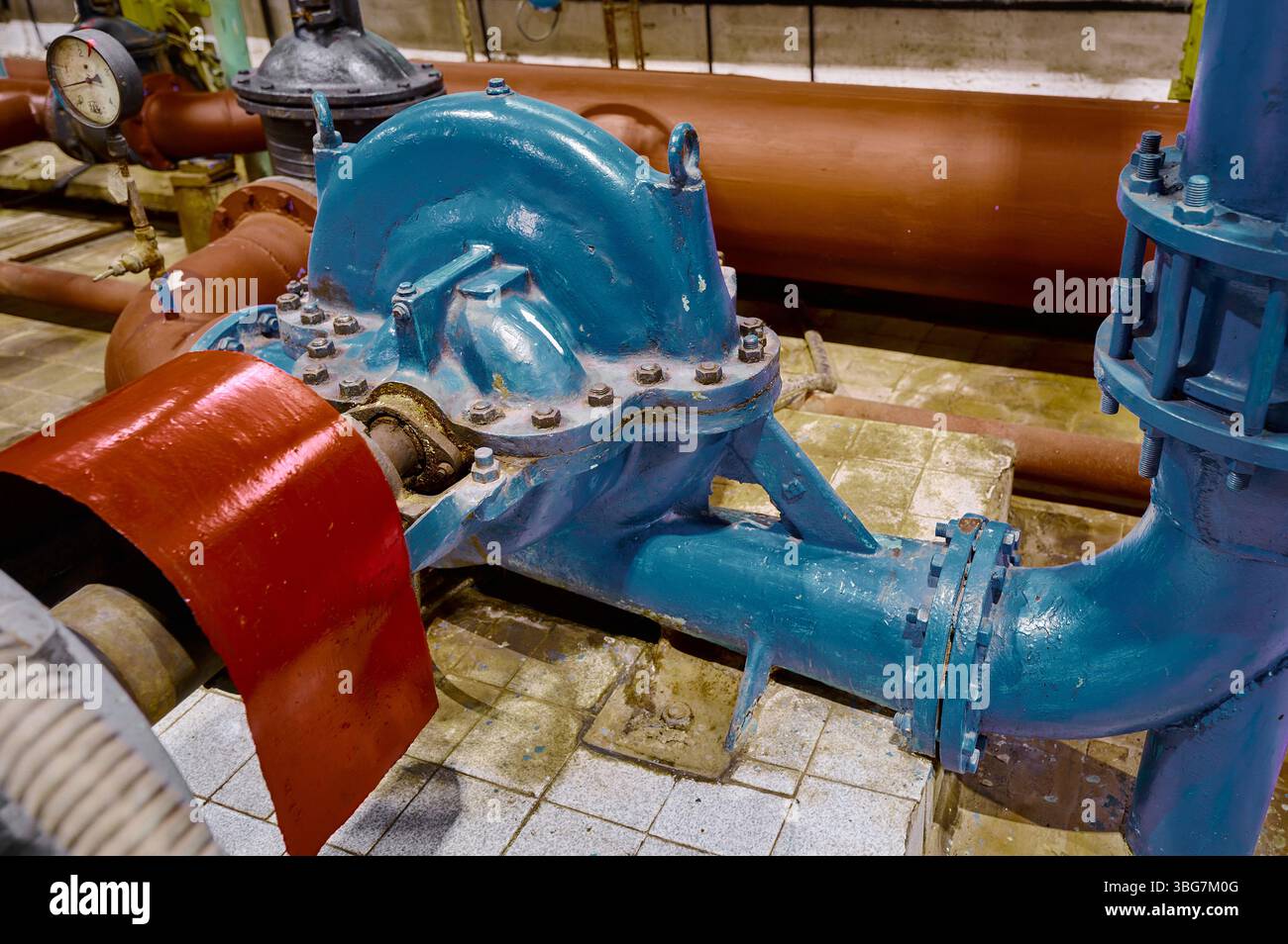 Pompe à eau industrielle et système de tuyauterie dans une installation présentant des travaux d'ingénierie et d'entretien pendant les heures de lumière du jour Banque D'Images