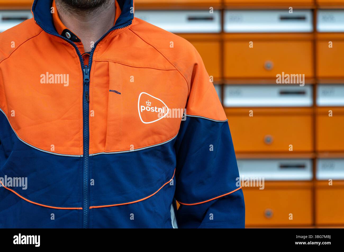 Amsterdam, pays-Bas, 02.06.2025, travailleur des postes néerlandais portant l'uniforme bleu et orange PostNL debout à côté des boîtes aux lettres résidentielles Banque D'Images