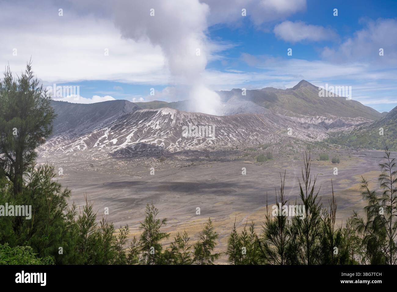 Vue de paysage de la caldeira de Tengger avec le volcan du mont bromo projetant un panache de fumée, parc national bromo Tengger Semeru, Java oriental, Indonésie Banque D'Images