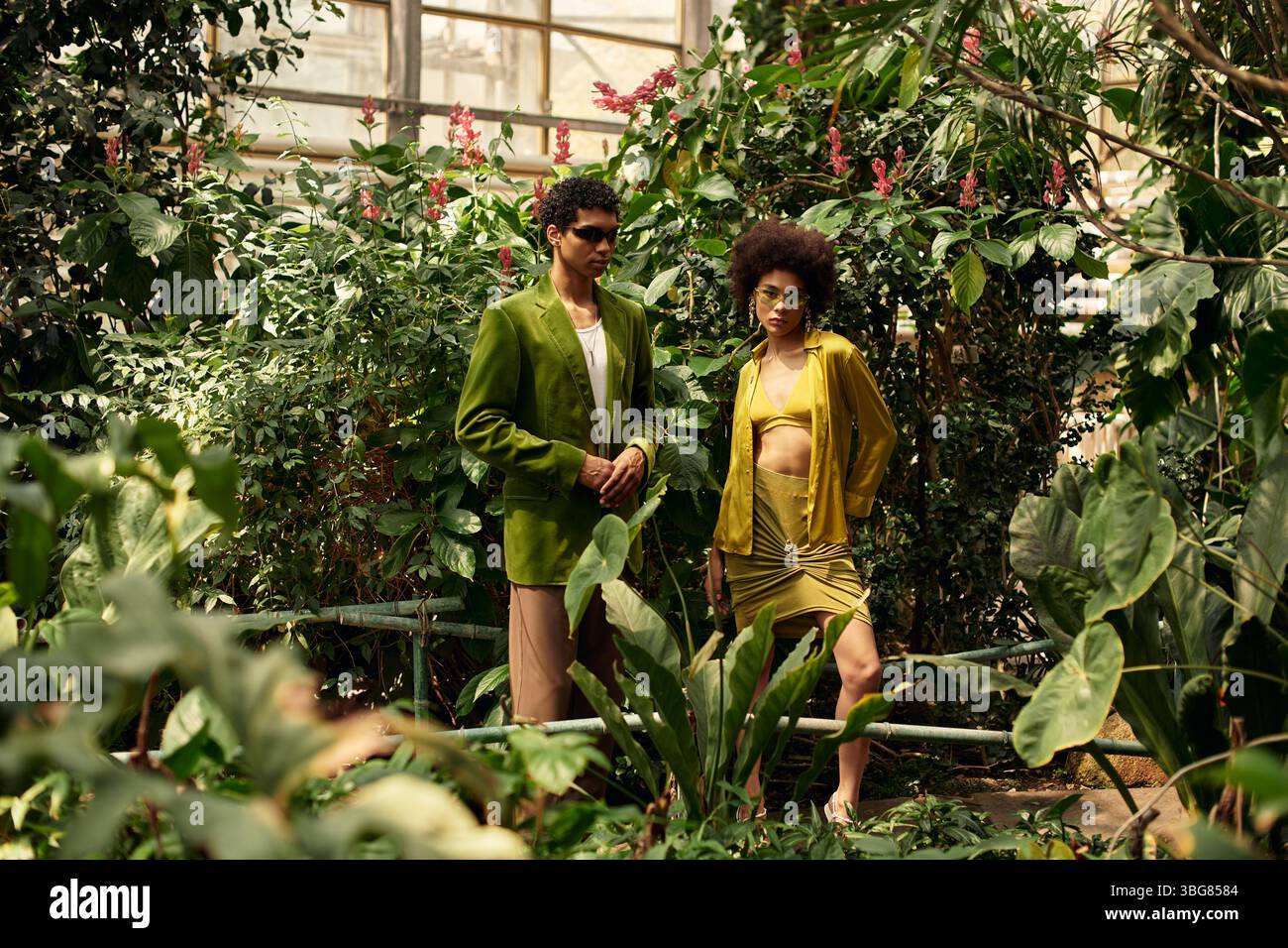 Un couple aimant profite d'un moment tendre au milieu d'une collection florissante de plantes dans une serre. Banque D'Images