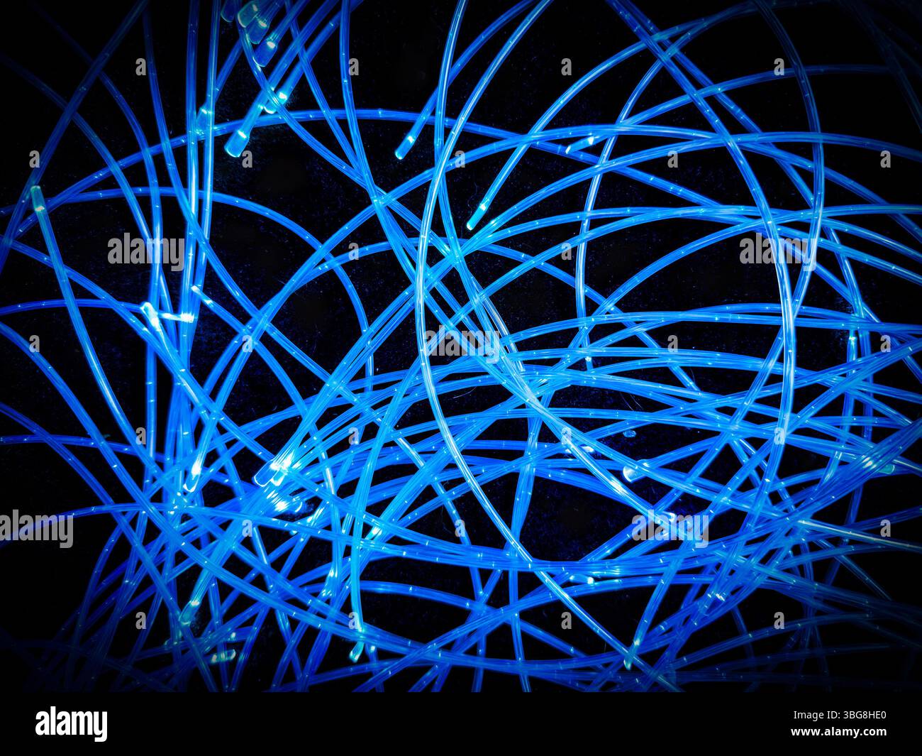 Arrangement abstrait de lumières LED bleues allumées ou allumées sur des fils enroulés sur un fond noir - Image de stock capturée avec un smartphone