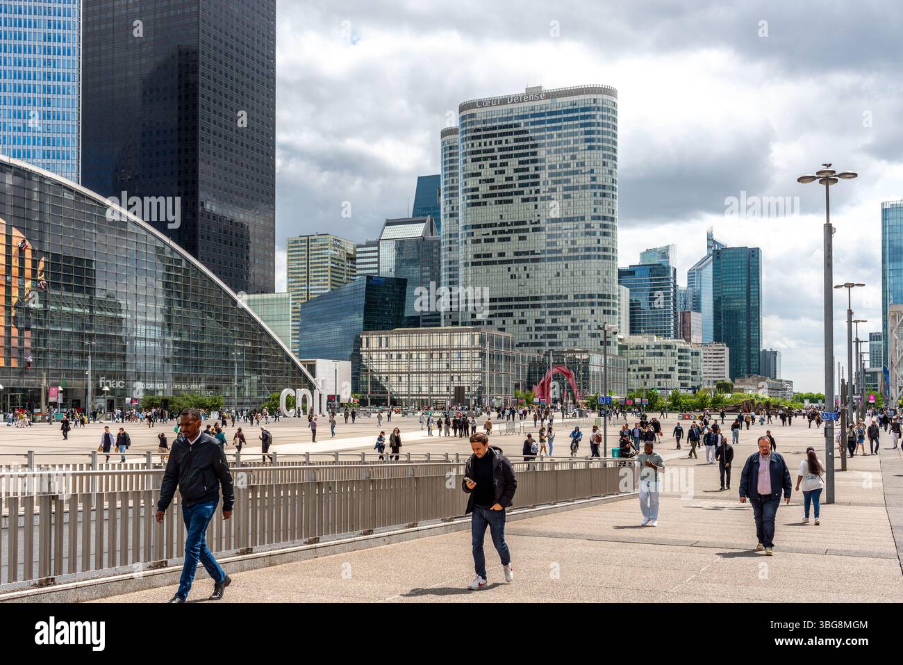 Des gens pendant le déjeuner à la Défense avec des gratte-ciel en arrière-plan. La Défense est le plus grand quartier d'affaires d'Europe construit à cet effet Banque D'Images
