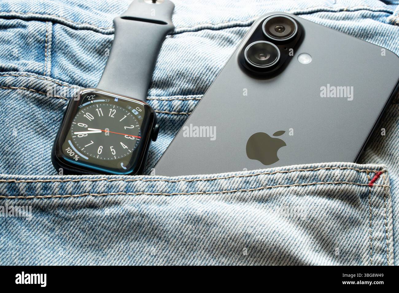Ukraine Dnipro 04-06-2025 Apple Watch et iPhone 16 sont dans la poche de jeans, gadgets modernes dans la lumière sur les vêtements Banque D'Images