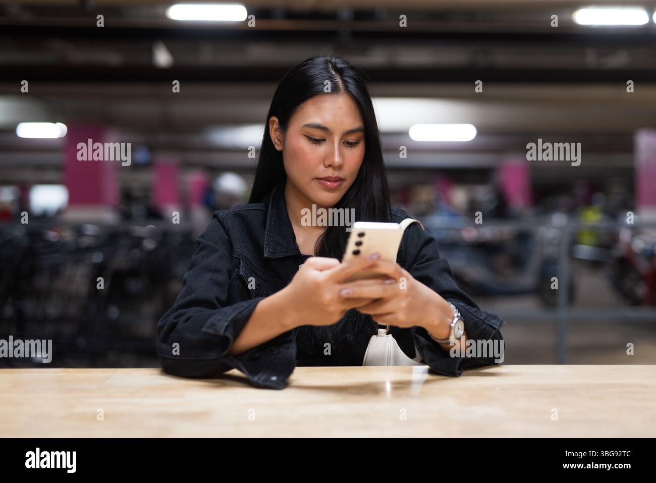 Portrait de jeune belle femme asiatique heureuse assise au parking pendant la nuit Banque D'Images