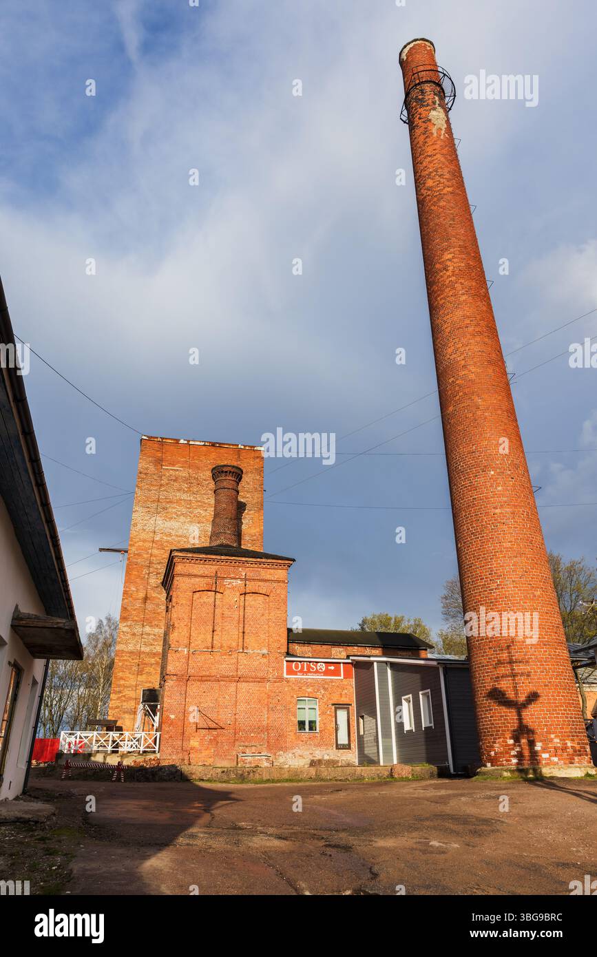 Vyborg, Russie - 3 mai 2025 : ancienne brasserie. Architecture industrielle en brique avec une grande cheminée contre un ciel bleu vif, capturant une ambiance historique Banque D'Images