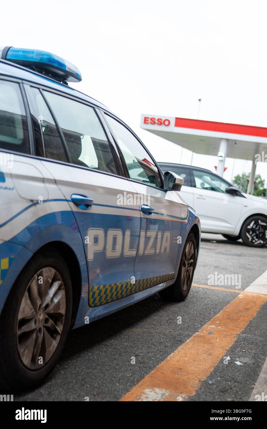 Italie - 4 juin 2025 : une voiture de patrouille de la police routière italienne est garée dans une aire de repos en Italie. Une station-service Esso peut être vue en arrière-plan - situation de contrôle ou de rupture sur l'autoroute. *** Ein Streifenwagen der Italienischen Autobahnpolizei steht an einem Rastplatz in Italien. IM Hintergrund ist eine Esso-Tankstelle zu sehen Kontroll- oder Pausensituation auf der Fernstraße. Banque D'Images