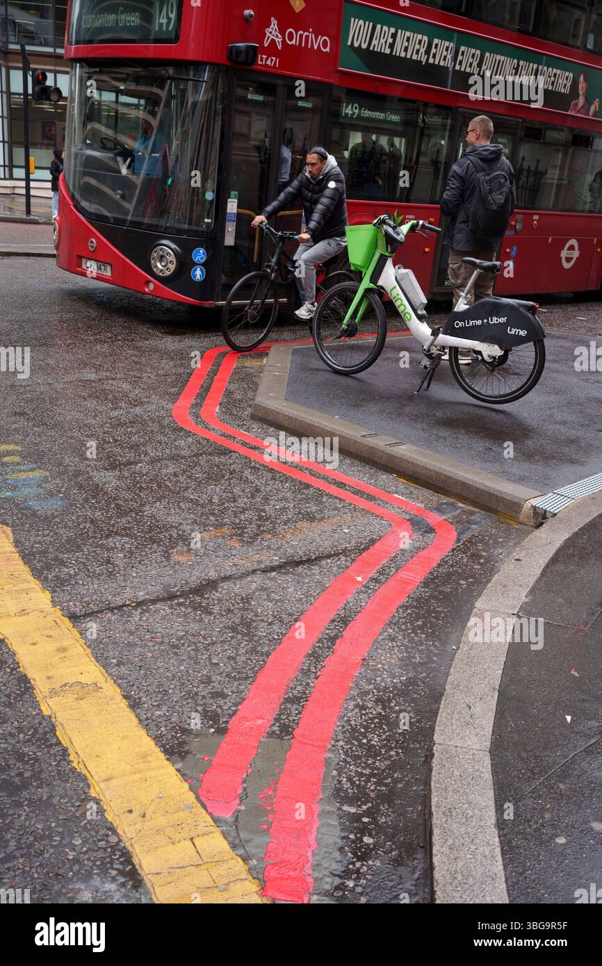 Un cycliste et un bus passent devant les lignes de stationnement de la route Rouge sur Gracechurch Street dans la ville de Londres, le quartier financier de la capitale, le 3 juin 2025, à Londres, en Angleterre. Banque D'Images
