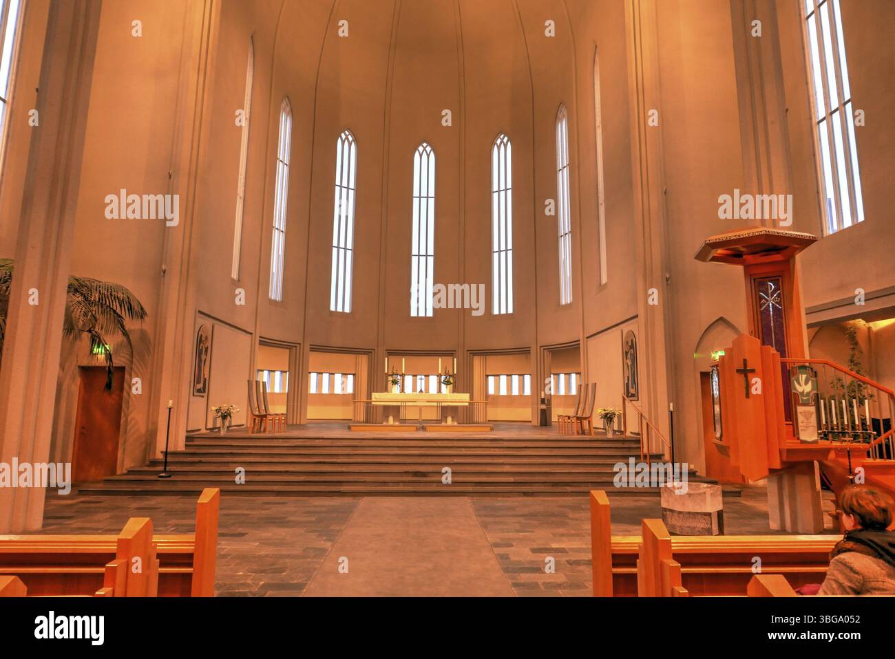 Hallgrimskirkja, avec sa flèche imposante, domine l'horizon de Reykjavik. Son design moderniste, l'intérieur de l'église dans une lumière jaune chaude Banque D'Images