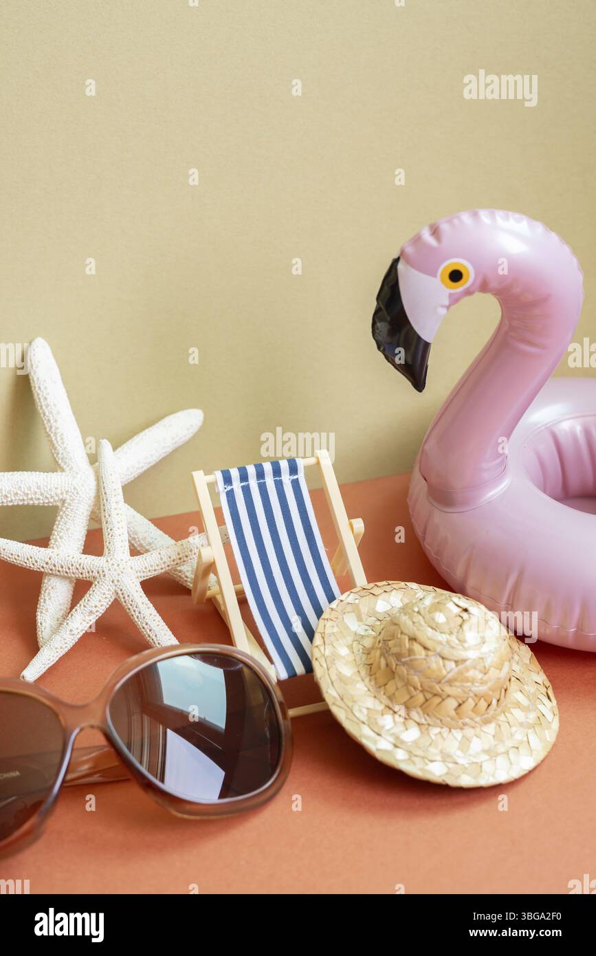 Concept de plage de vacances d'été. Lit de soleil, étoile de mer, chapeau de paille, lunettes de soleil, tube de natation sur fond rouge et beige kaki Banque D'Images
