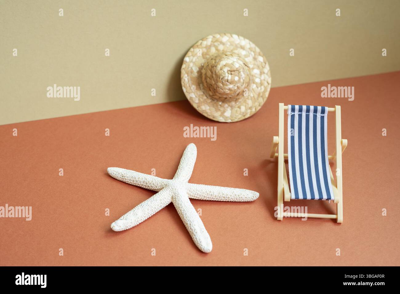 Concept de plage de vacances d'été. Lit de soleil, étoile de mer, chapeau de paille sur fond rouge et beige kaki Banque D'Images
