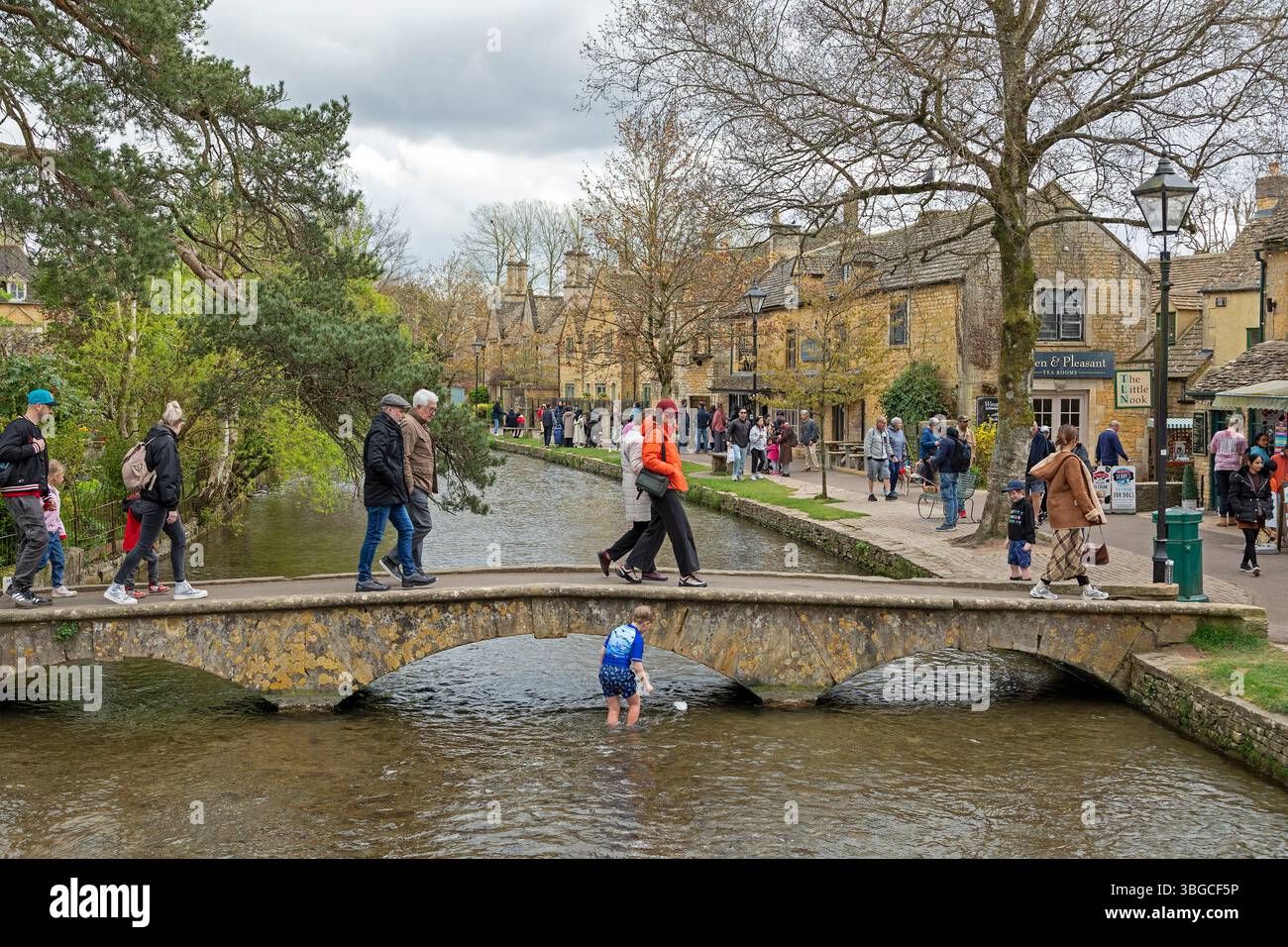 Pont, River Windrush, gens, garçon jouant dans l'eau, maisons, arbres, Bourton-sur-l'eau, les Cotswolds, Gloucestershire, Angleterre, Grande-Bretagne Banque D'Images