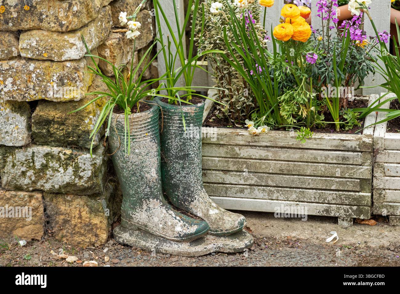 Vieilles bottes utilisées comme pots de fleurs, fleurs, Bourton-sur-l'eau, les Cotswolds, Gloucestershire, Angleterre, Grande-Bretagne Banque D'Images