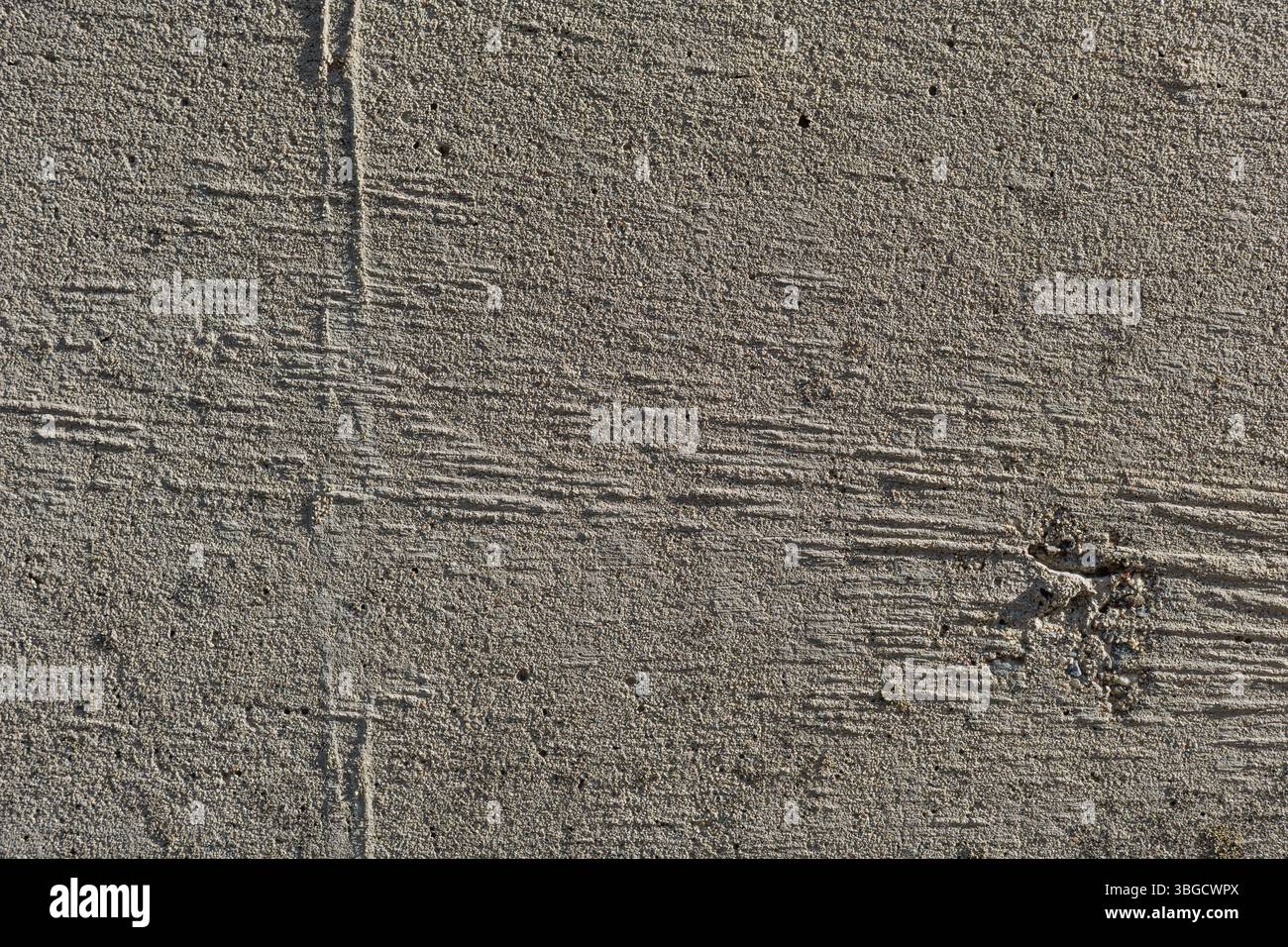 Texture de béton rugueux présentant des détails de surface, des motifs naturels et des matériaux de conception. Le gros plan souligne la robustesse et les tons terreux. Banque D'Images