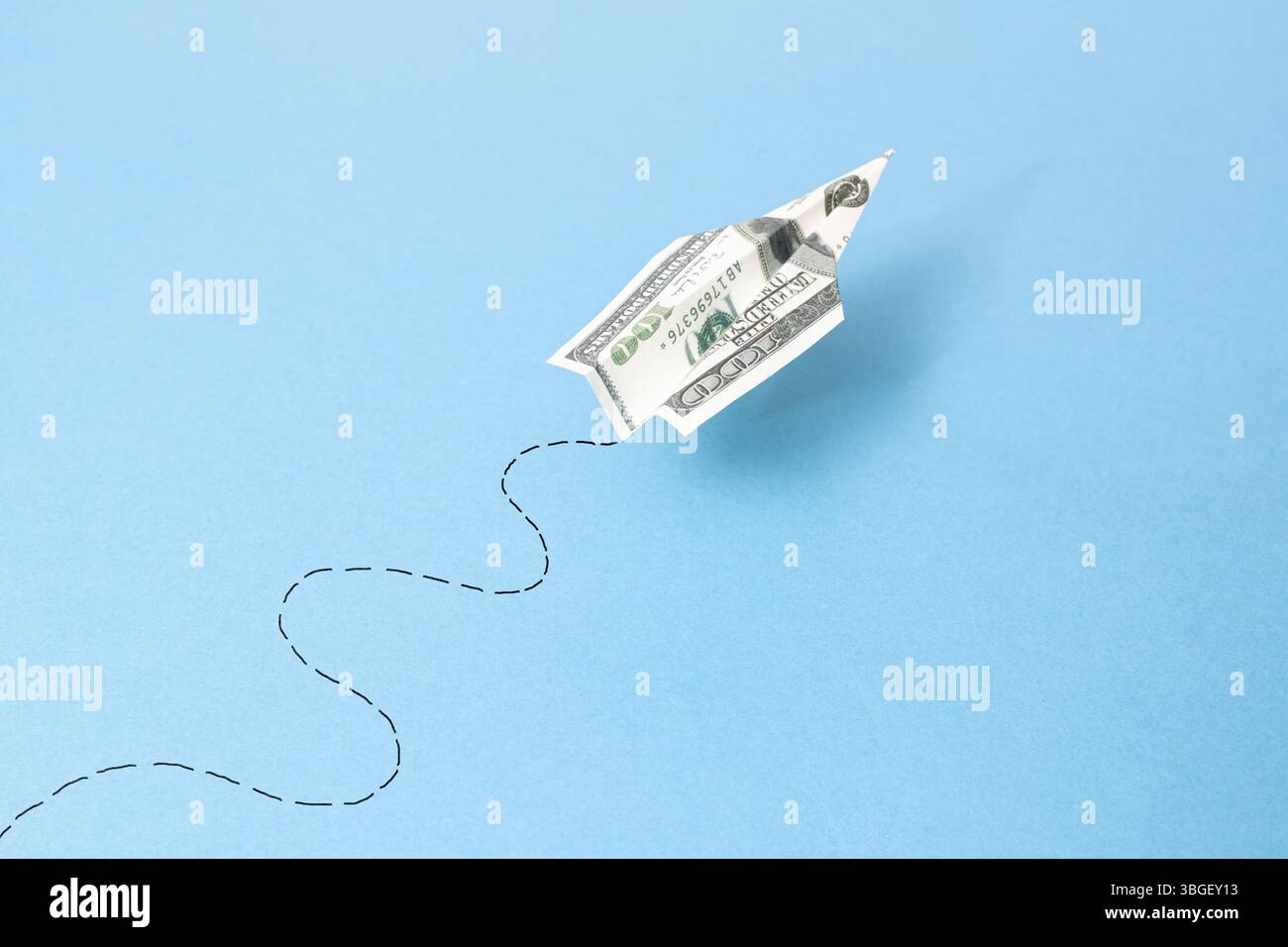 billet d'avion dollar volant et son chemin sur fond bleu Banque D'Images