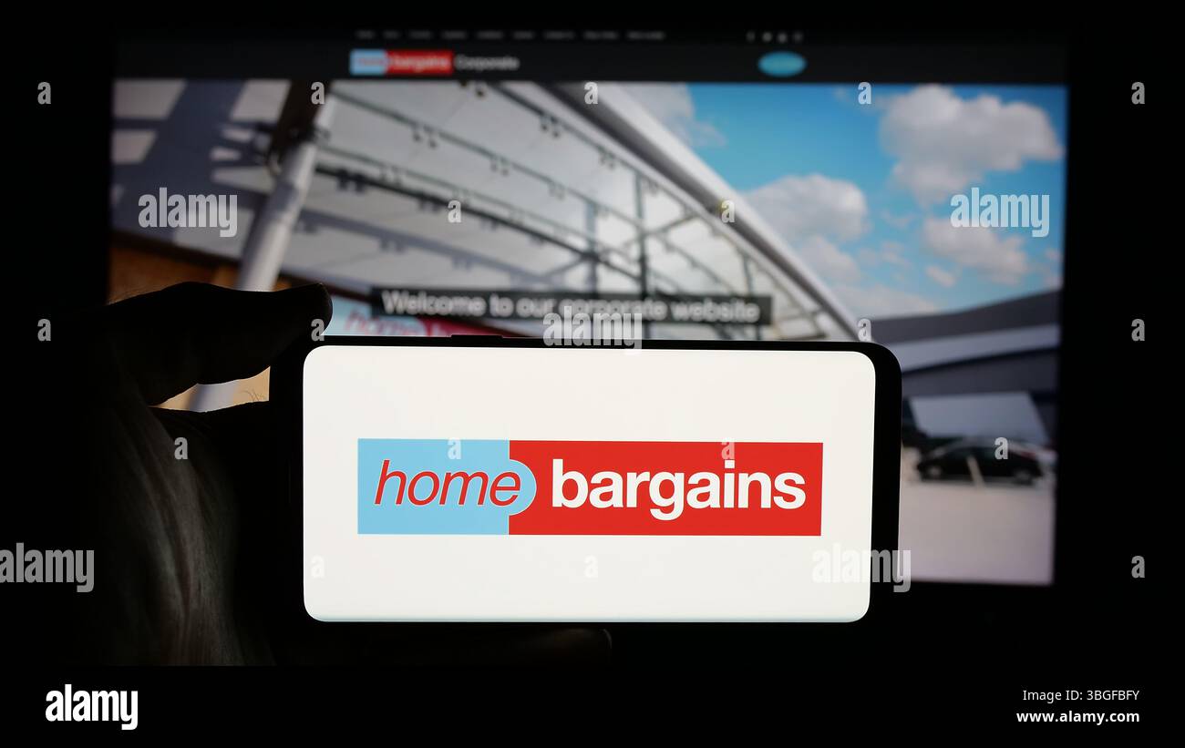 Stuttgart, Allemagne - 03-13-03 2025 : personne tenant un téléphone portable avec le logo de la société britannique T.J. Morris Limited (Home Bargains) sur l'écran Banque D'Images