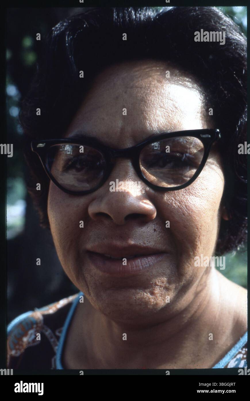 Une femme aux cheveux foncés et aux montures noires est photographiée, bien que son identité reste inconnue. La photo remonte à environ 1978. Banque D'Images