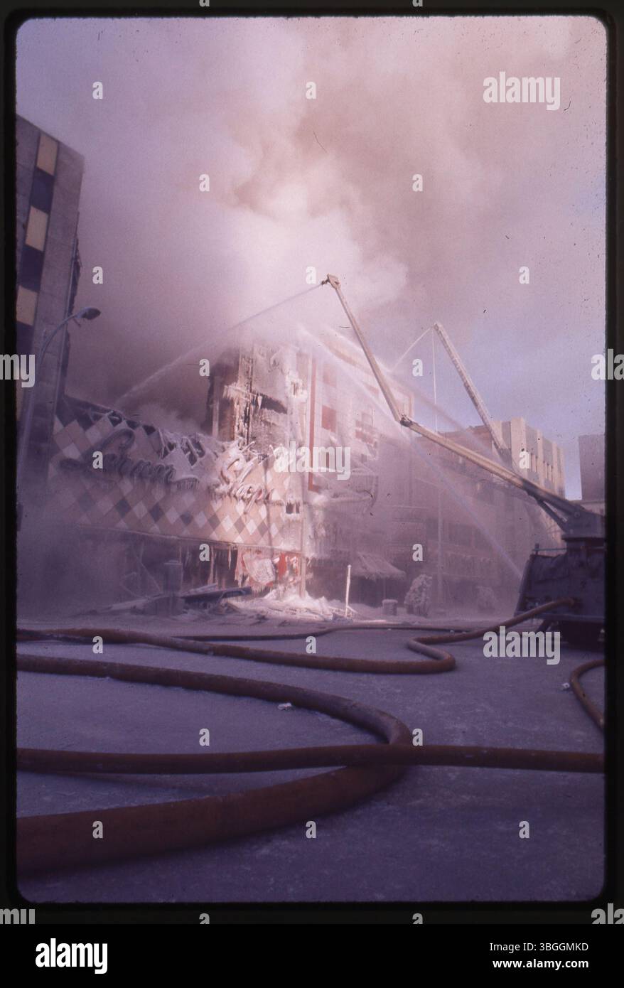 Cette photo montre des pompiers pulvérisant de l'eau sur les boutiques Lerner après un incendie qui s'est propagé de K's Down Under Bar le 17 février 1977. L'incendie, exacerbé par des températures de 9 degrés, a détruit plusieurs magasins et causé des dommages de 2 millions de dollars. Banque D'Images
