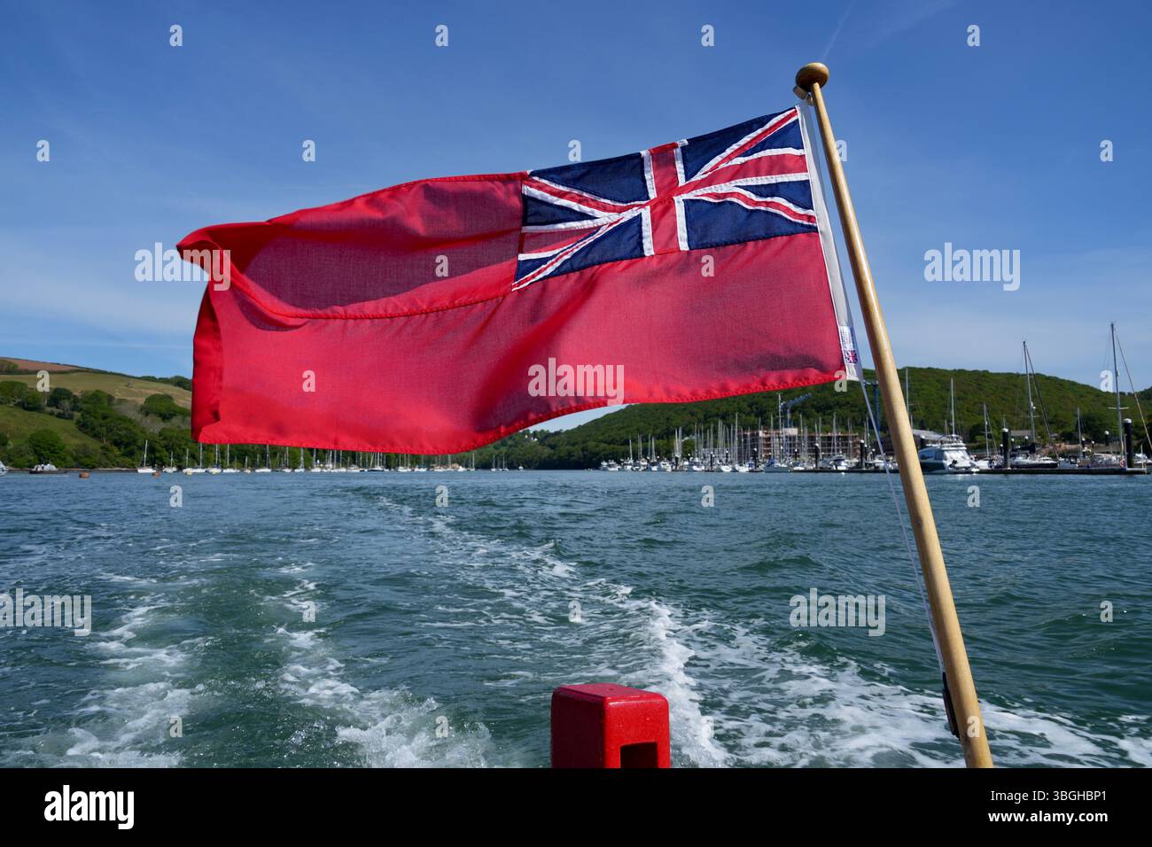 Drapeau Red Ensign volant d'un bateau sur la rivière Dart. Banque D'Images