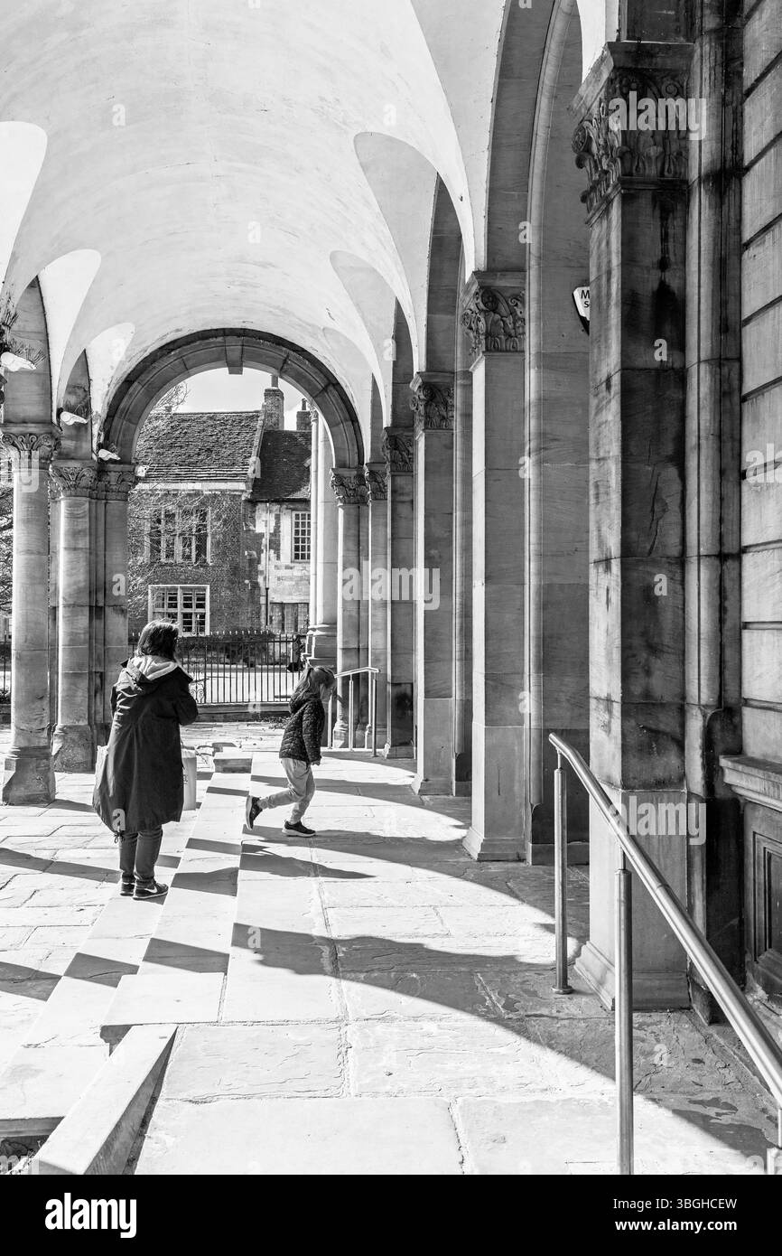 Une femme et un enfant marchent sous une arche de pierre à la York Art Gallery, North Yorkshire, Royaume-Uni. Banque D'Images