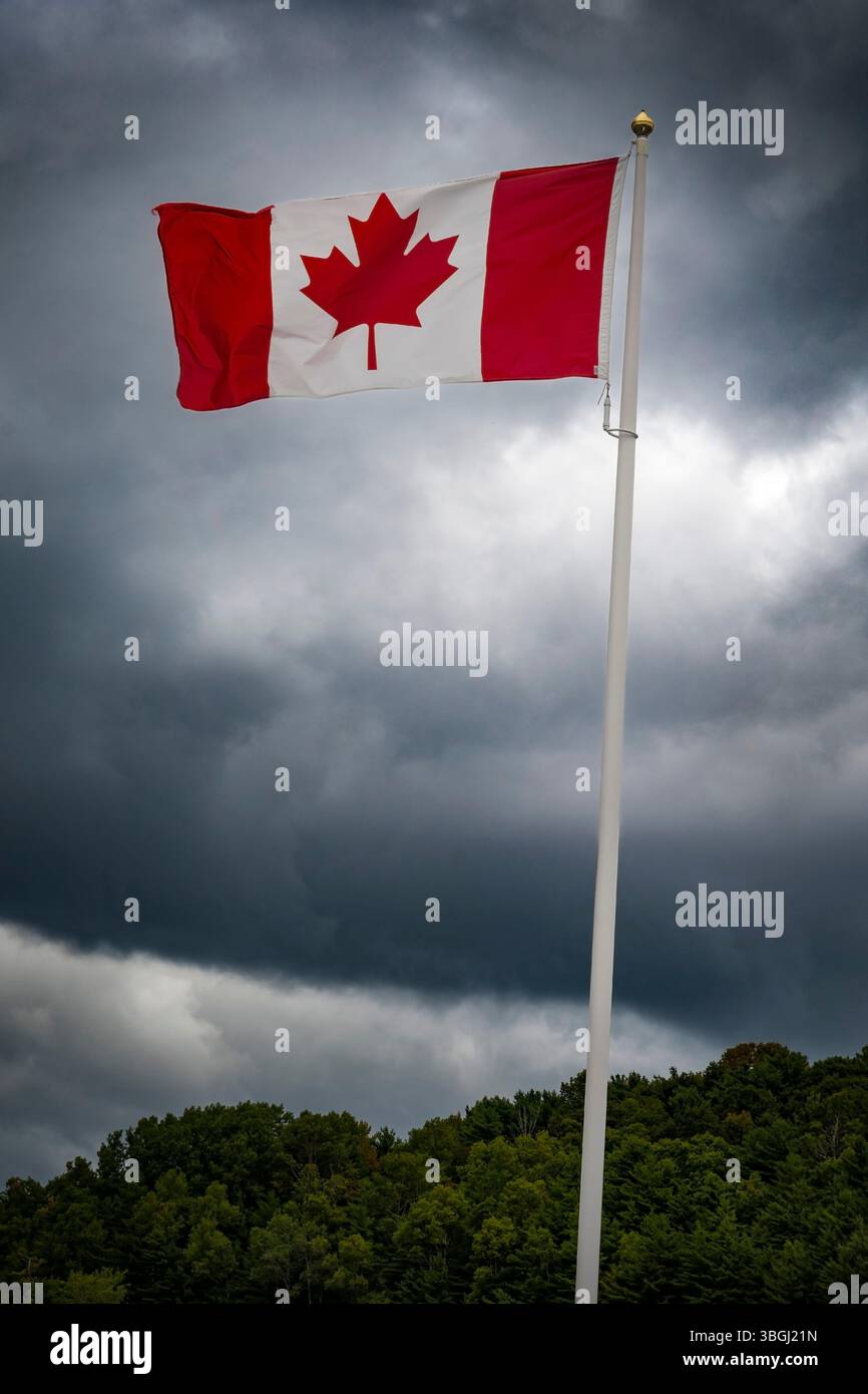 Drapeau du Canada volant contre un ciel sombre et sombre Banque D'Images