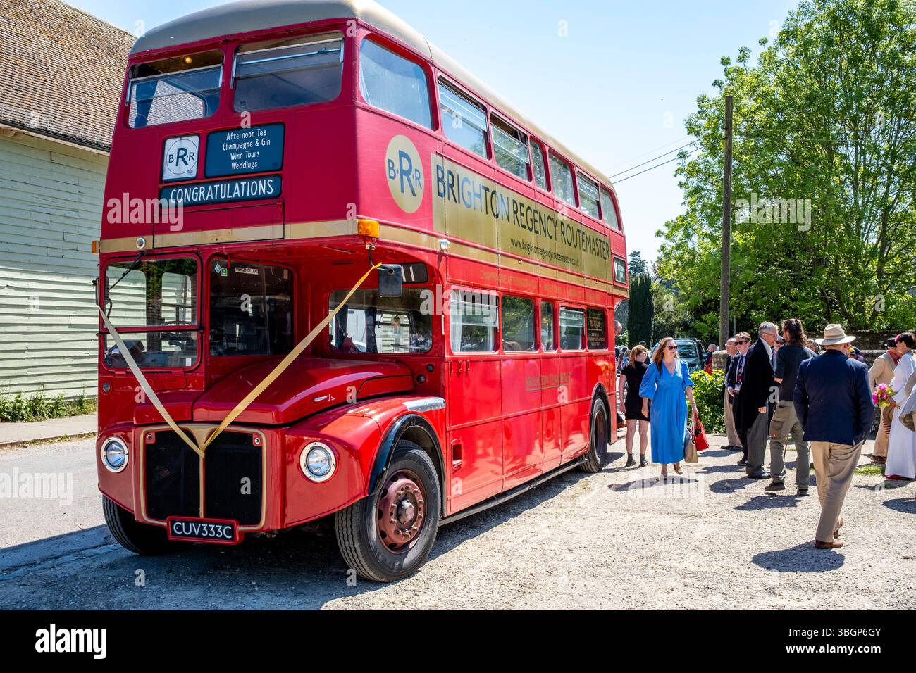 Les invités de mariage lors D'Une visite de la ville débarquent dans le pittoresque village de Stanmer à la périphérie de Brighton, Sussex, Royaume-Uni. Banque D'Images