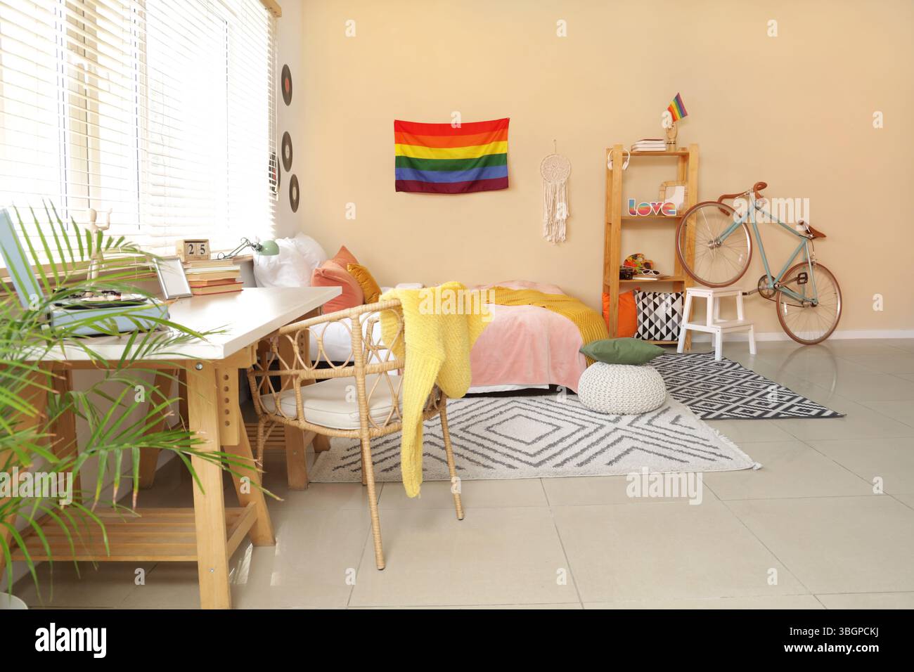 Intérieur de la chambre avec drapeau LGBT, vélo et lieu de travail Banque D'Images