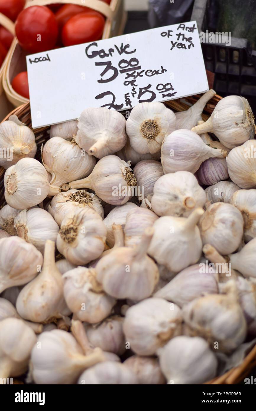 Affichage de l'ail avec un prix au marché des agriculteurs Banque D'Images
