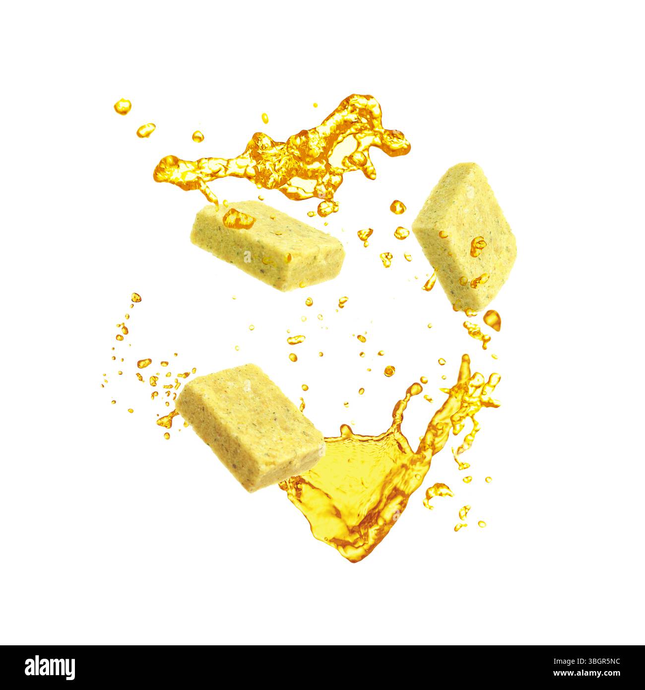Éclaboussure de bouillon et cubes de bouillon dans l'air sur fond blanc Banque D'Images