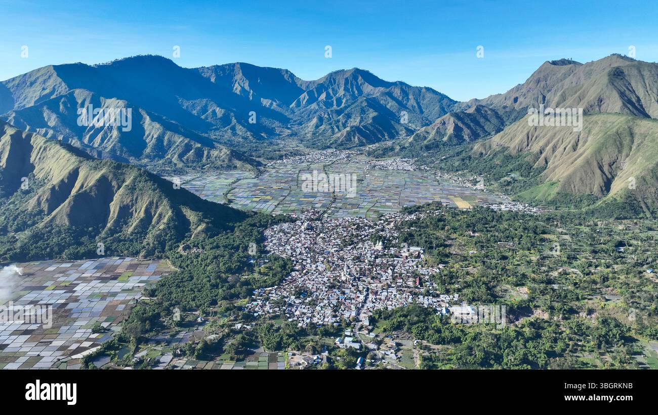 Le village de Sembalun et ses champs colorés se nichent dans une vaste caldeira entourée de sommets imposants. La vue capture le cœur de la beauté volcanique de Lombok. Banque D'Images
