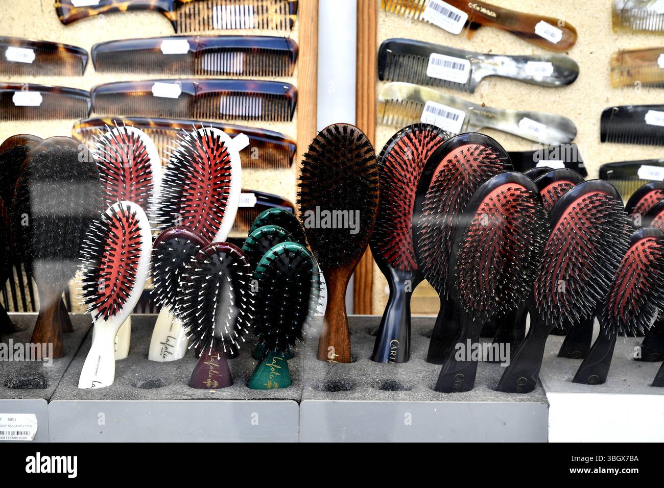 Une vitrine de magasin présentant un assortiment de brosses à cheveux avec des poils naturels et des peignes en plastique à Paris, France Banque D'Images