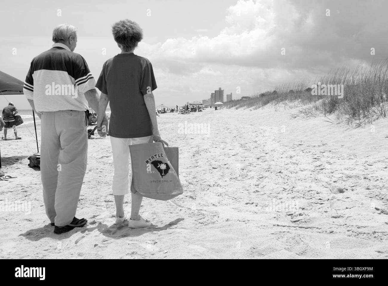 Couple caucasien se tenant la main en marchant le long de Myrtle Beach, Caroline du Sud, États-Unis. Banque D'Images