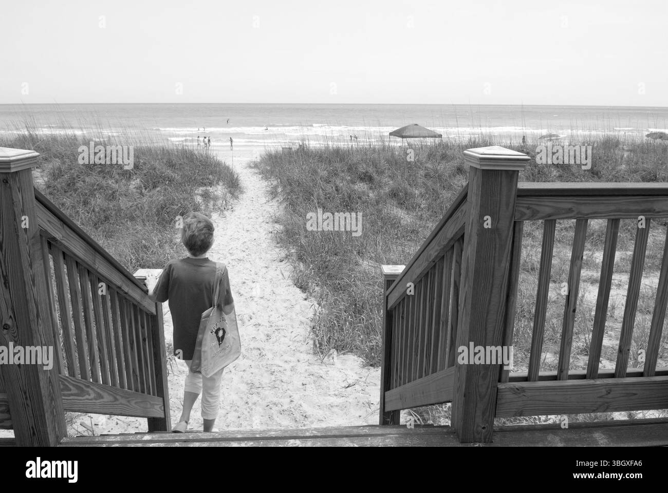 Femme caucasienne se tient sur des marches donnant sur l'océan Atlantique à Myrtle Beach, Caroline du Sud, États-Unis. Banque D'Images