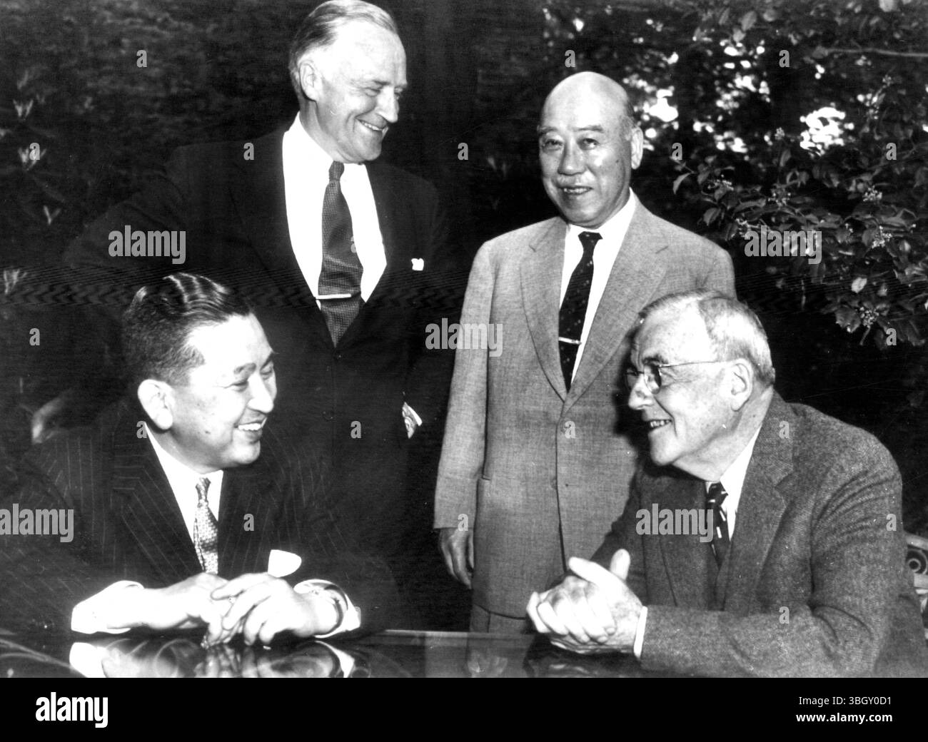 Le ministre japonais de l'Agriculture, Ichiro Kono (assis à gauche), discute avec le secrétaire d'État américain John Foster Dulles (assis à droite) lors d'une réunion dans la maison de ces derniers pour discuter des problèmes de pêche du Japon et de questions politiques plus larges. On y voit le secrétaire d'État adjoint Walter Robinson (à gauche) et l'ambassadeur japonais Masayuki Tani. 19 mai 1956 Banque D'Images