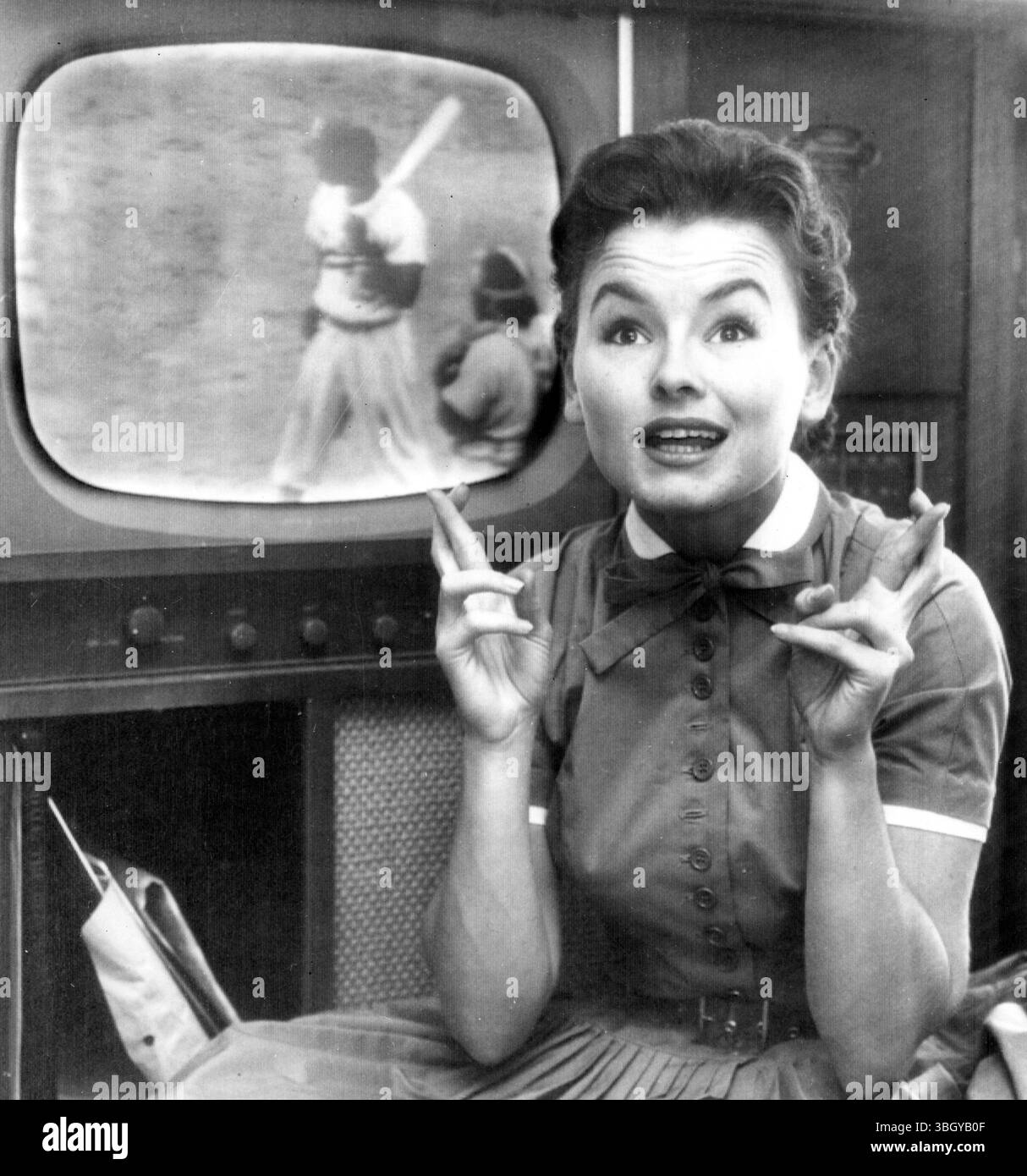 L'actrice Lucy Marlow, qui doit épouser Andy Carey, 3e joueur des Yankees, croise les doigts dans une tentative d'hexagone les Dodgers alors qu'elle regarde la série mondiale sur son téléviseur. 2 octobre 1955 Banque D'Images L'actrice Lucy Marlow, qui doit épouser Andy Carey, 3e joueur des Yankees, croise les doigts dans une tentative d'hexagone les Dodgers alors qu'elle regarde la série mondiale sur son téléviseur. 2 octobre 1955 Banque D'Images