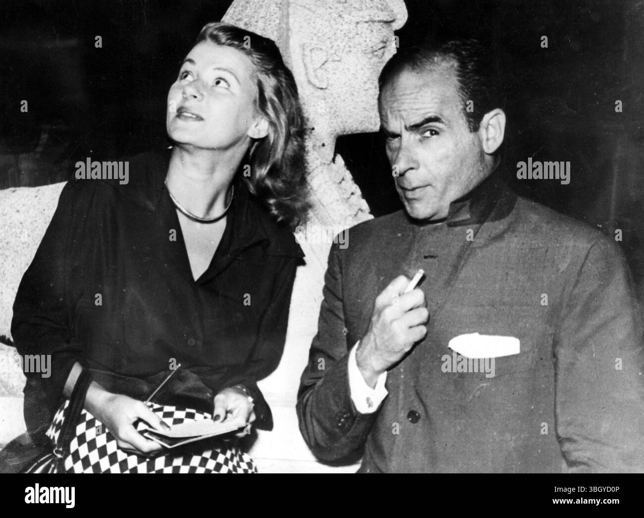 Même s'il est à l'aise pour le Festival International du film de Venise, l'acteur américain Mark Lawrence conserve le rôle de méchant homme, qui est son titre dans le commerce à l'écran. Il ne semble pas avoir beaucoup d'effet sur sa compagne, l'actrice anglaise Jackie Frost. 25 août 1952 Banque D'Images