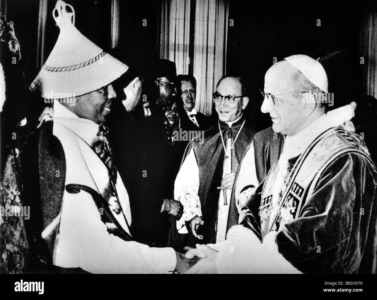 Le pape Paul VI (à droite) serre la main de Joseph Riffat Lary Kotsokoane, le 1er ambassadeur du Lesotho auprès du Saint-Siège, qui portait un chapeau originaire de son pays. Kotsokoane a présenté ses lettres de créance au pontife avec 10 autres nouveaux ambassadeurs au Vatican. 8 février 1968 Banque D'Images