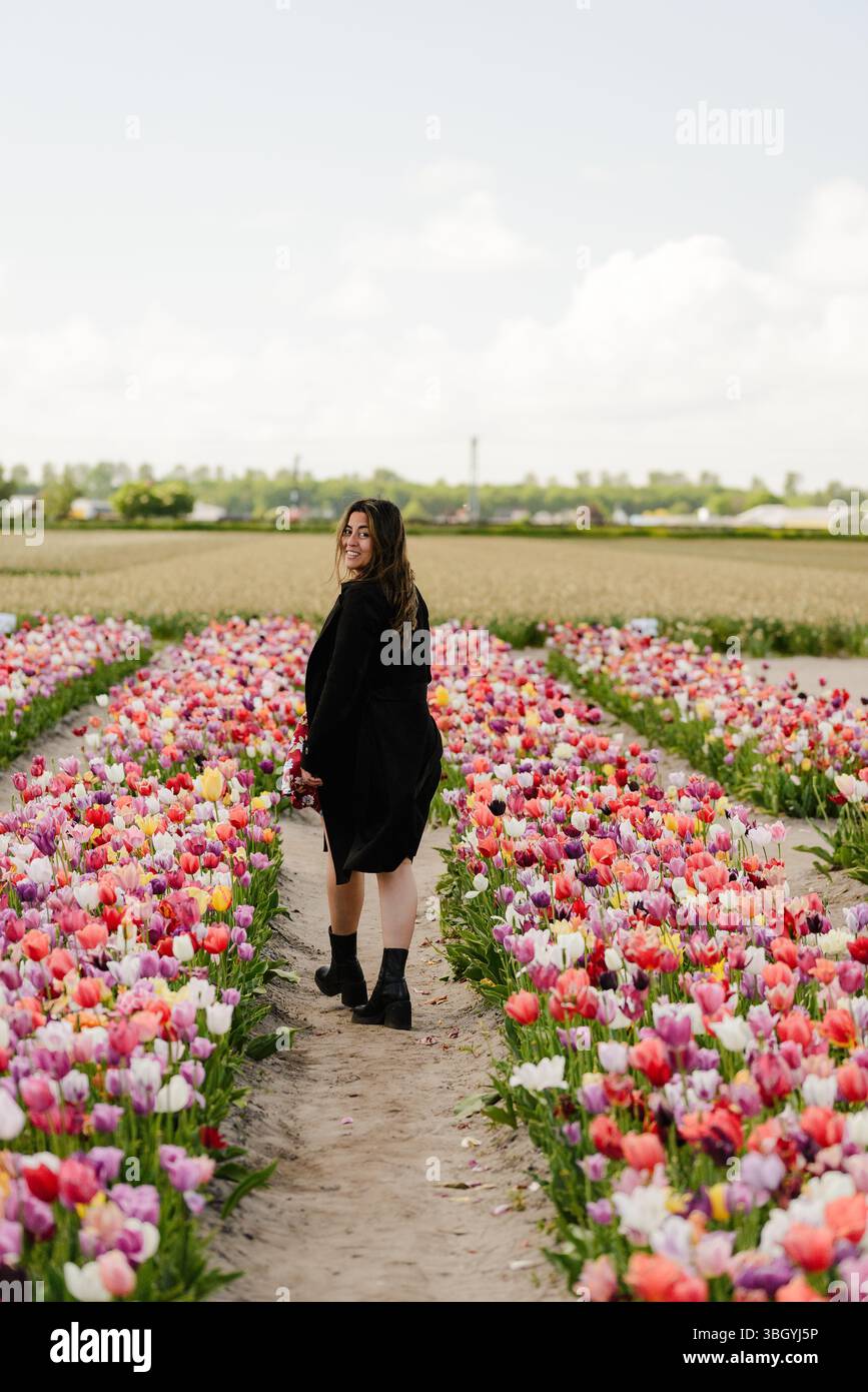 Femme marchant entre Tulip Rows dans Hillegom Garden Banque D'Images