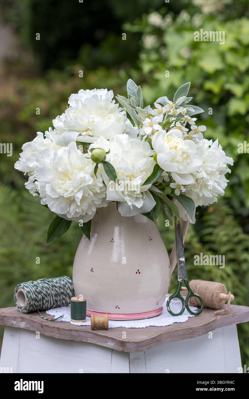 bouquet de fleurs de pivoine blanche dans un vase rustique dans le jardin Banque D'Images