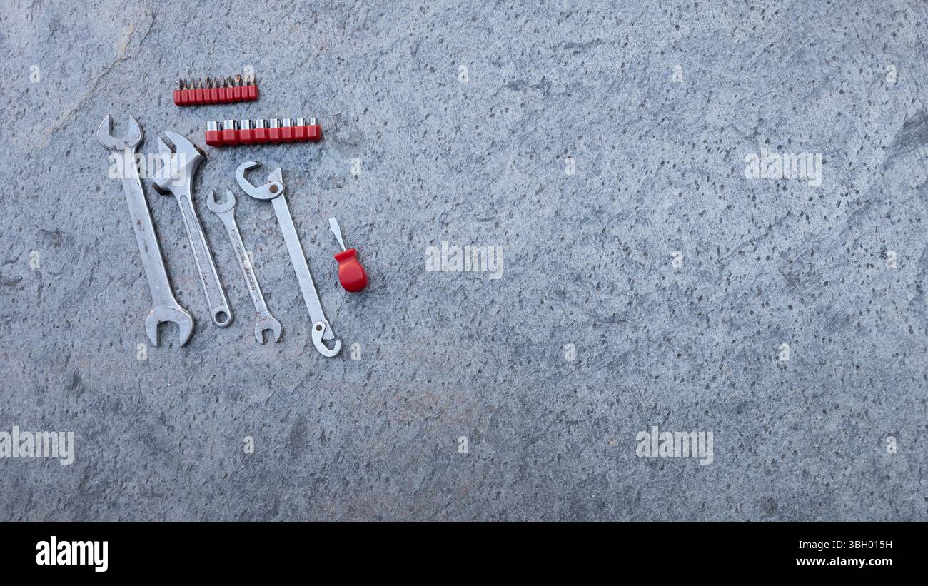 Outils de travail professionnels reposant sur une surface en béton, prêts à être utilisés pour l'entretien et la réparation Banque D'Images