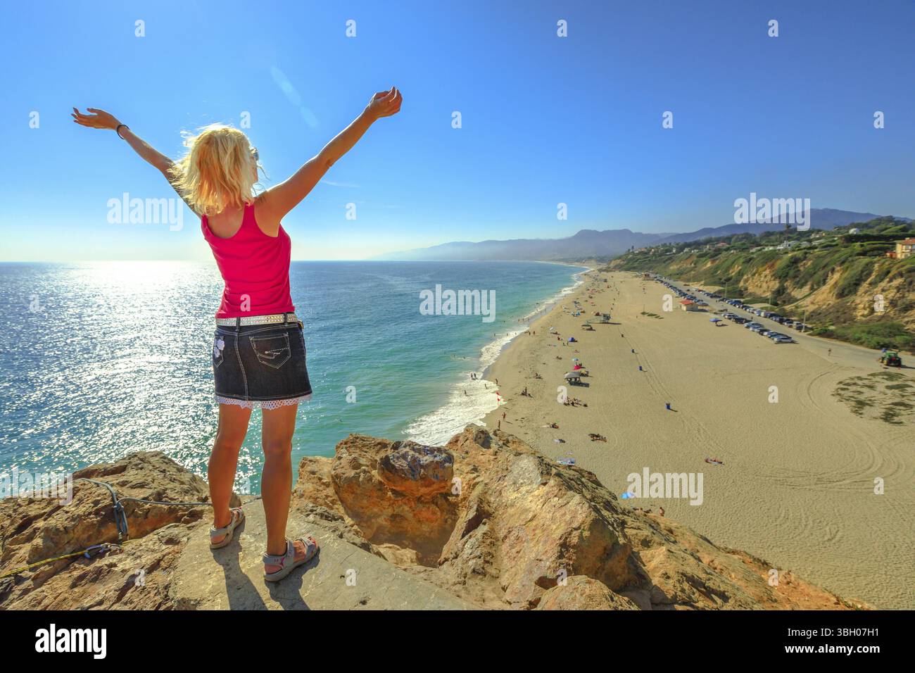 Femme caucasienne regardant point Dume State Beach de point Dume promontoire sur la côte de Malibu en CA, États-Unis. Femme insouciante à bras ouverts à Cali Banque D'Images